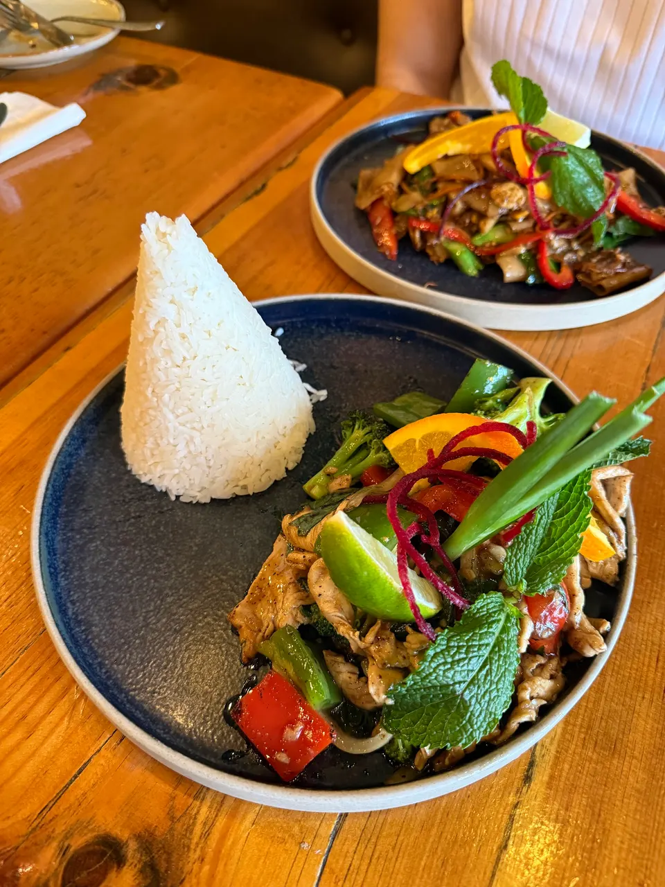 A beautifully presented Thai stir-fry with a cone of white rice at Imm Thai Kitchen.