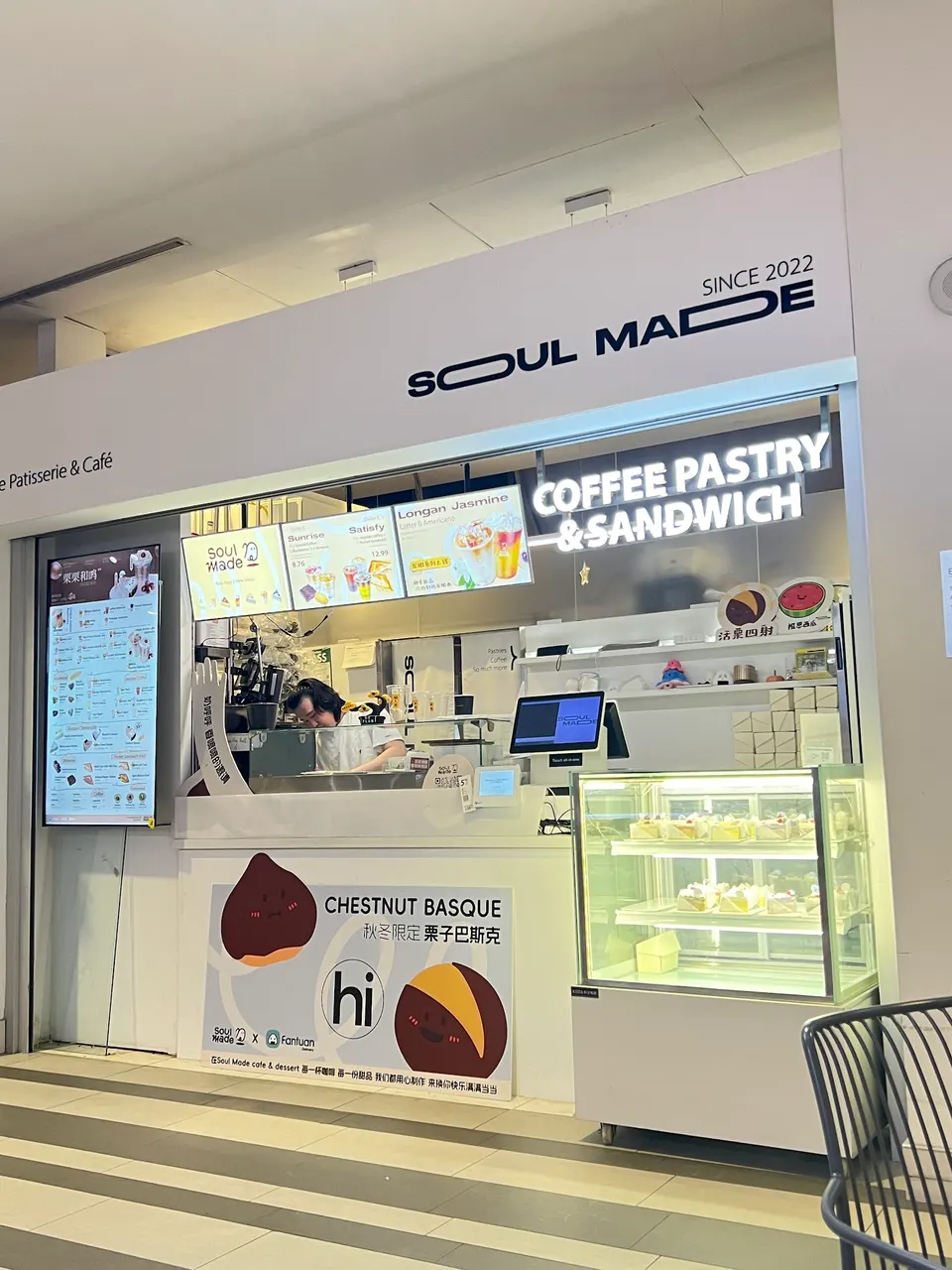 A modern storefront for Soul Made Cafe with a white counter, digital menu boards, a glass display case with pastries, and a large sign reading 'COFFEE PASTRY & SANDWICH'