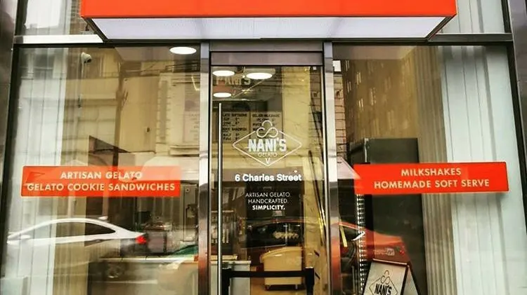 The glass storefront of Nani's Gelato on Charles Street, featuring orange signage for artisan gelato, cookie sandwiches, milkshakes, and homemade soft serve.