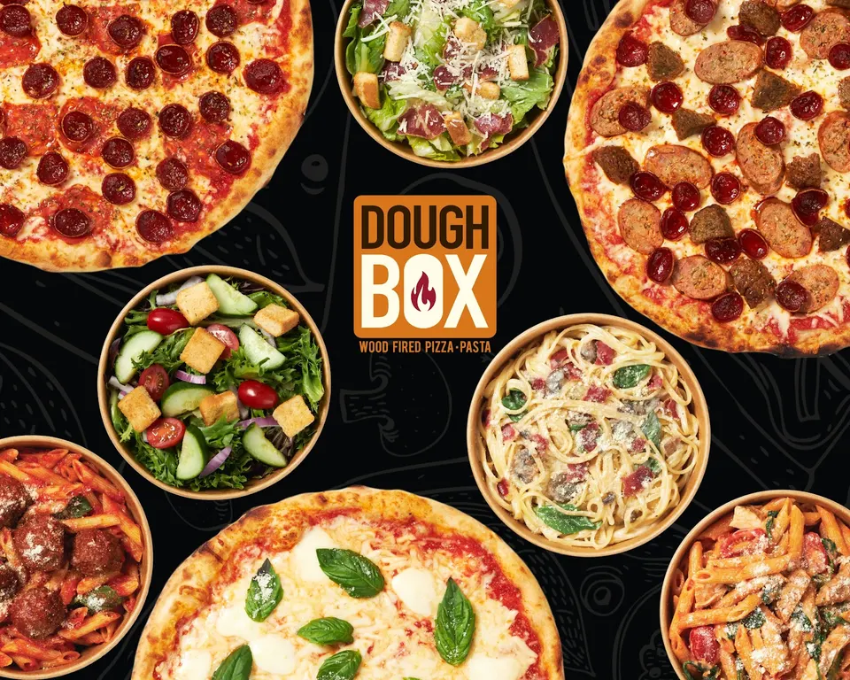 A flat lay arrangement of three wood-fired pizzas, two fresh salads, and three pasta dishes surrounding a central DoughBox logo on a dark background.